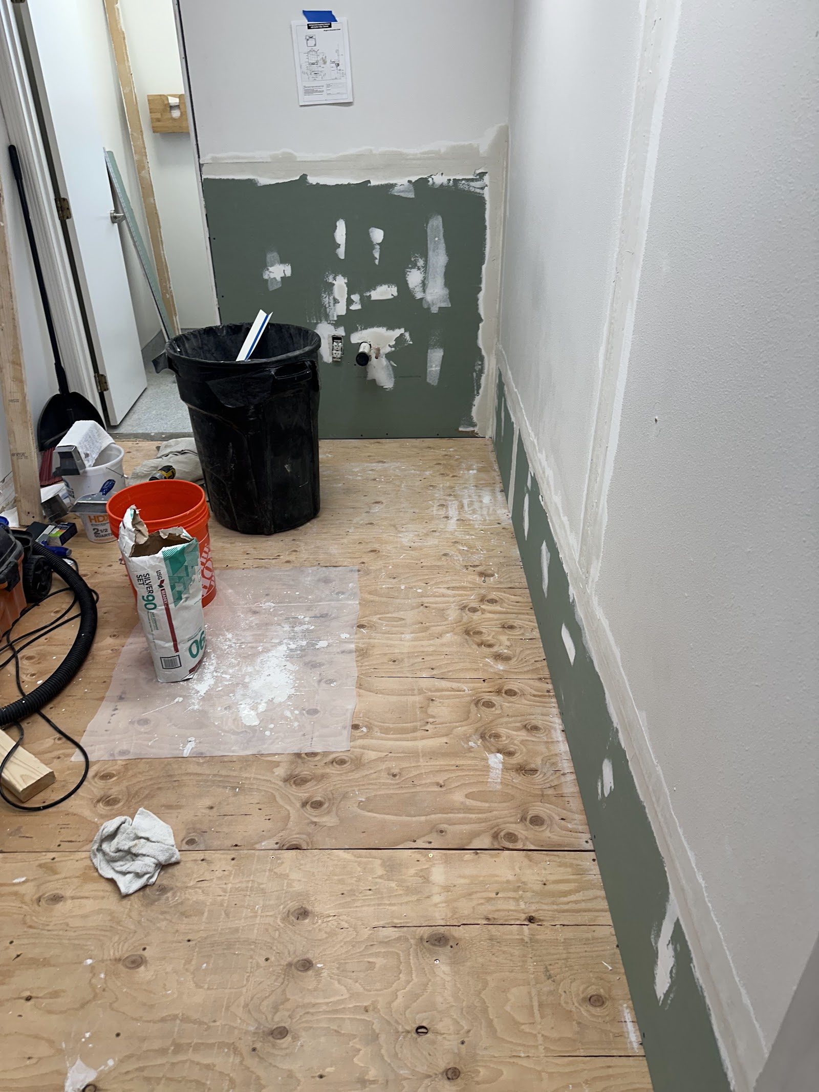 New subfloor and patched drywall in the hallway during repairs
