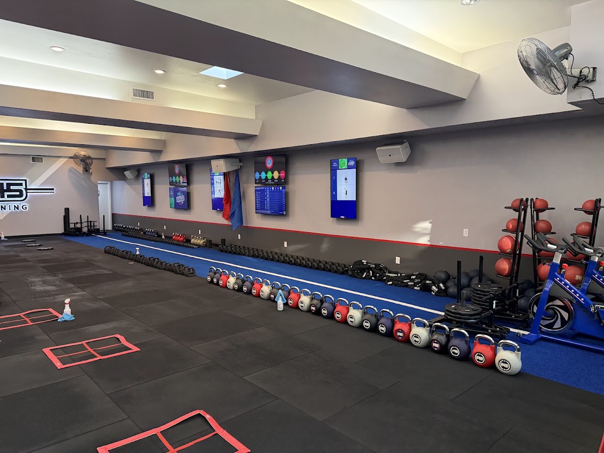 Finished F45 Queen Anne training floor with turf lane, kettlebells, and wall displays