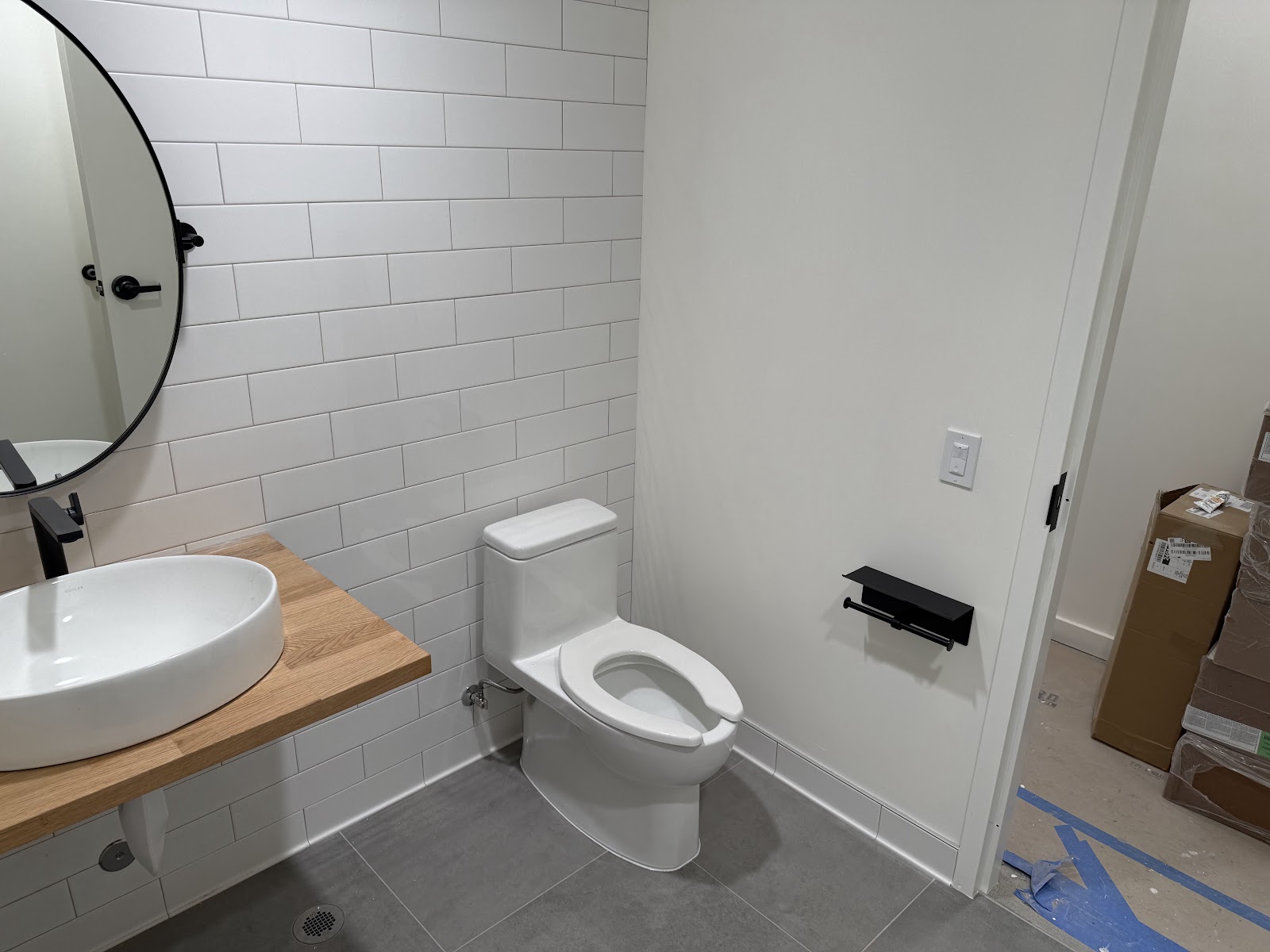Finished restroom with tiled walls, vanity, and accessible fixtures