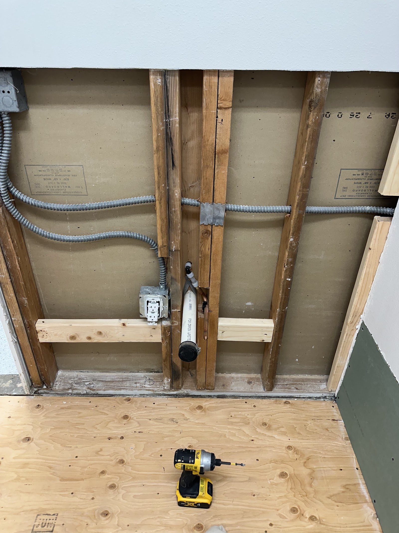 Close-up of framing, wiring, and the new water line in the wall