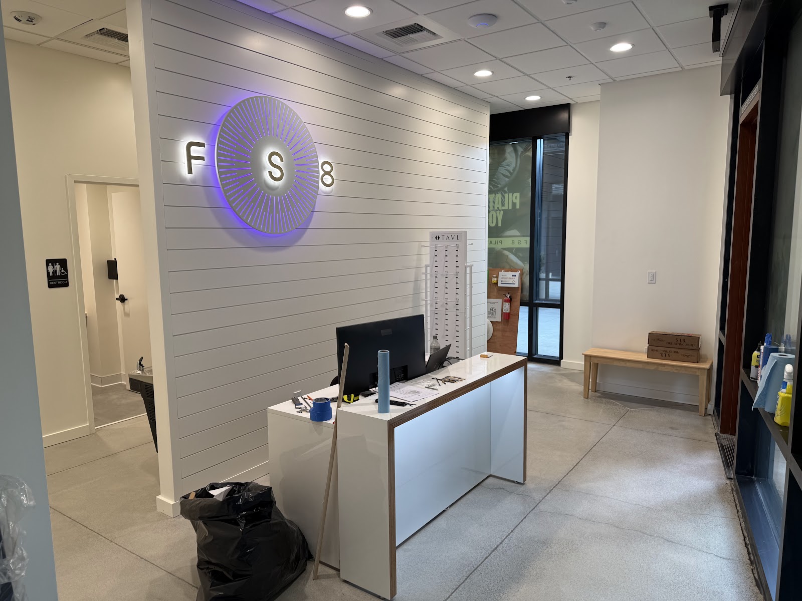 FS8 reception desk with illuminated brand logo on a slatted feature wall